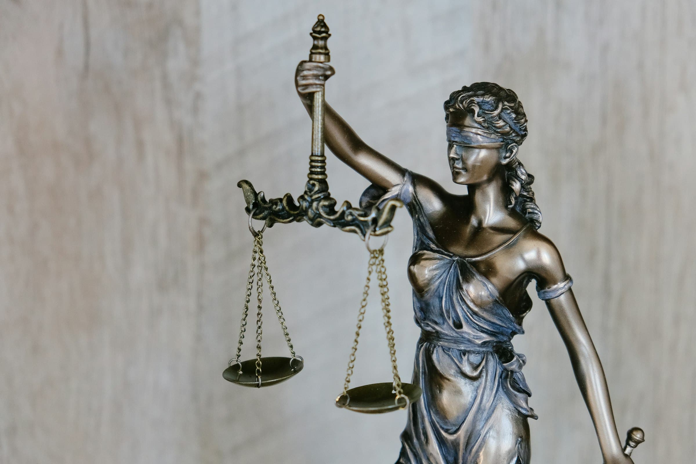 Bronze Lady Justice holding balanced scales — Assed Law, a boutique litigation and criminal defense firm in Albuquerque